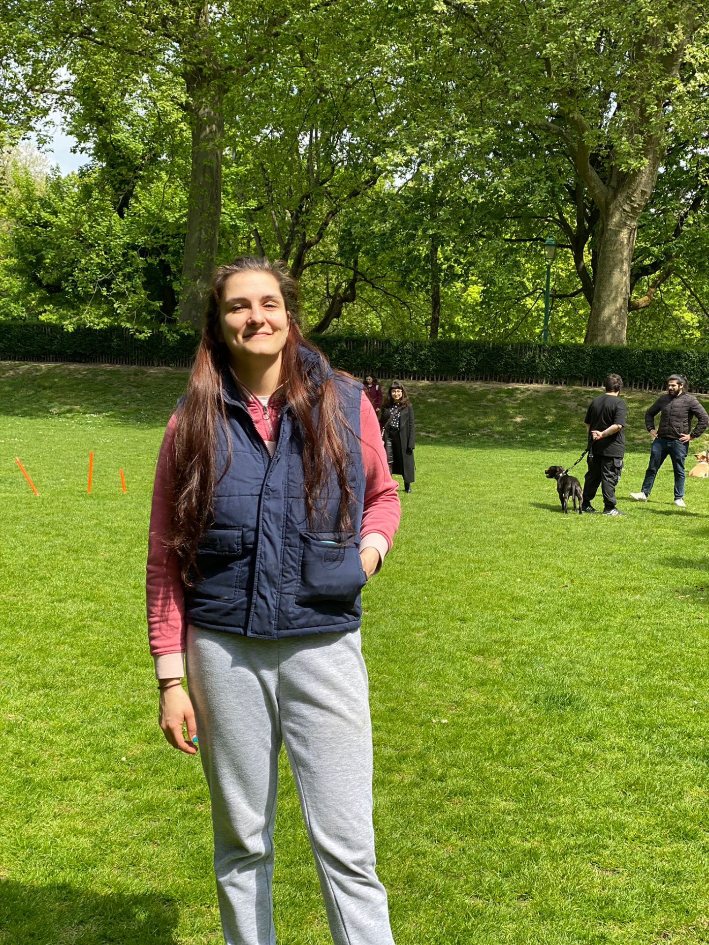 Em, dog behaviour trainer, standing in a park during a training class